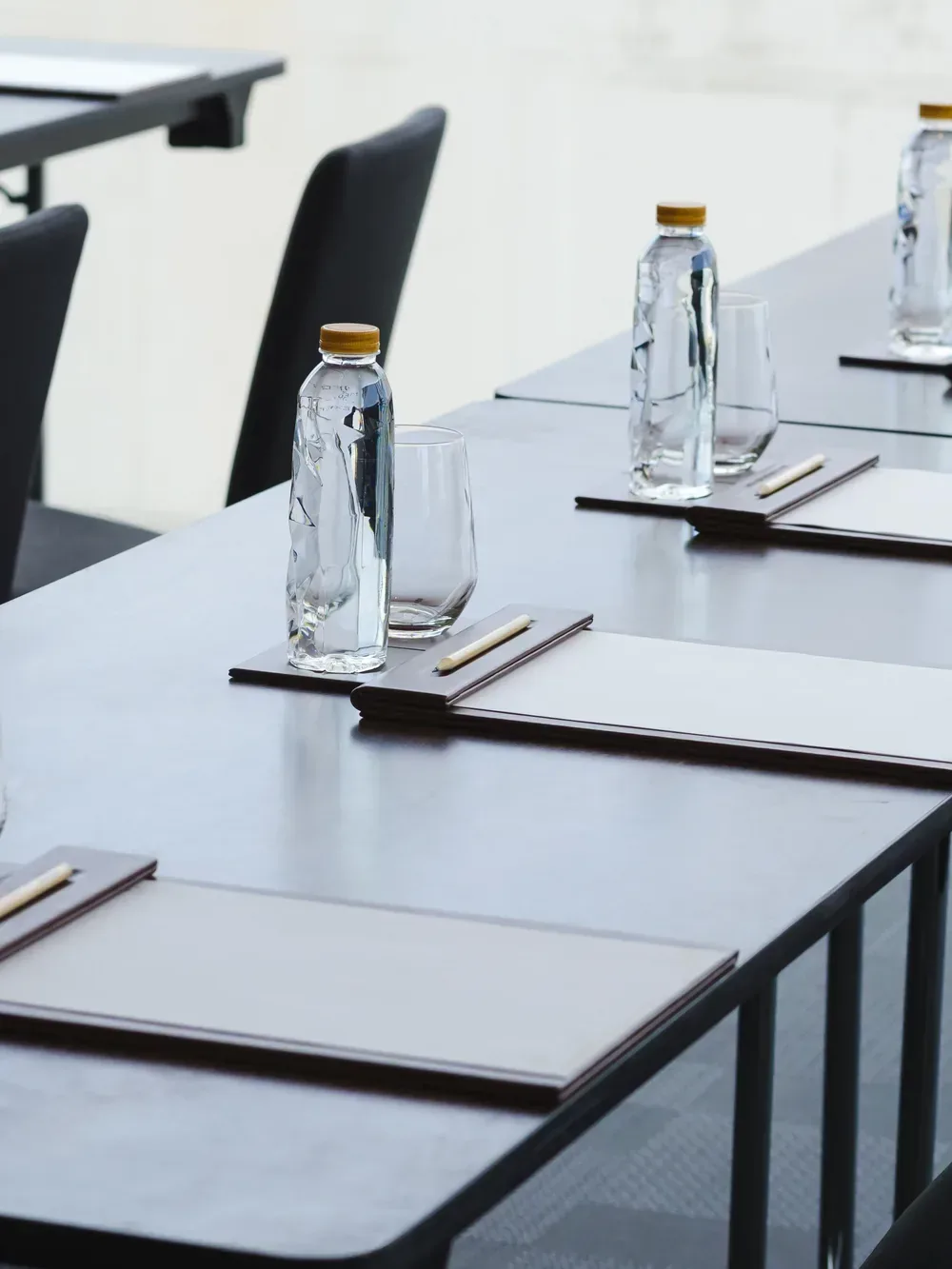 Professionell eingedeckter Seminarraum mit Wasserflaschen und Schreibunterlagen