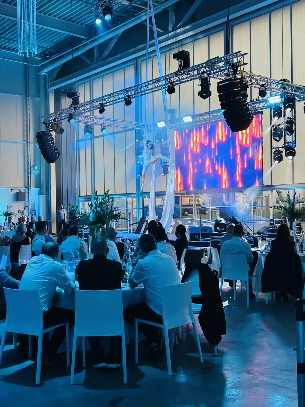Firmenevent mit Gästen an runden Tischen im Hangar bei aircraft events